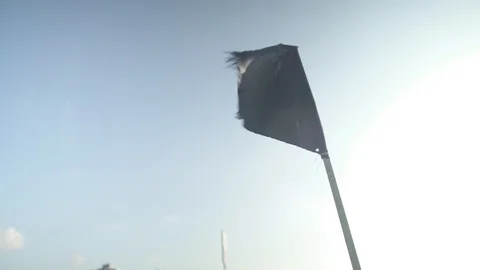Close Up of a black flag waving in the wind on the beach Stock Footage 88731167