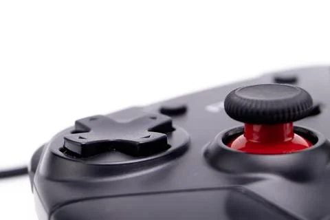 Close-up of a Black Game Controller with Red Joystick on White Background. Stock Photos