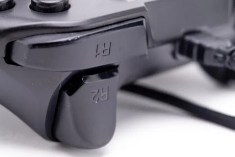Close-up of Black Game Controller Shoulder Buttons R1 and R2 with Cable on .. Stock Photos