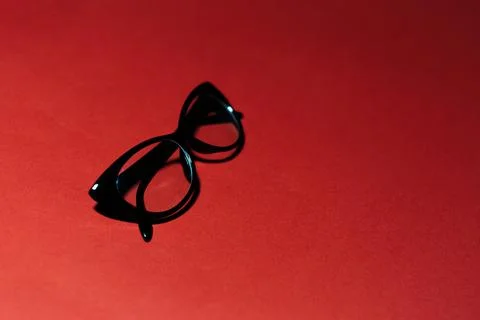 Close-up of black glasses on studio background of red color with copy space. Stock Photos