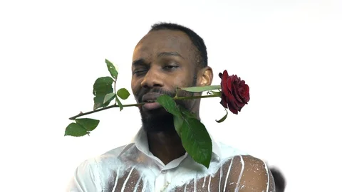 Close-up, Black Guy in the White Improvised Shirt, Keeps the Teeth with a Red Stock Footage 86259436