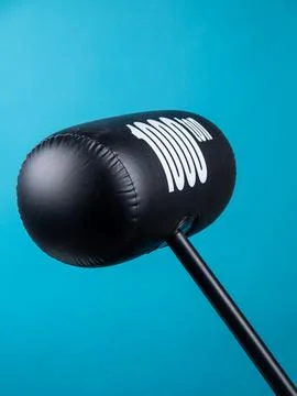 Close up of black inflatable hammer for fun party on blue background Stock Photos