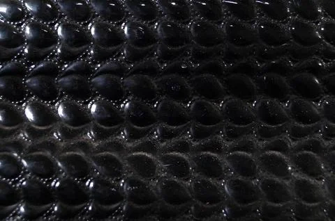 A close up of a black leather item with a pattern of small black dots Foto stock