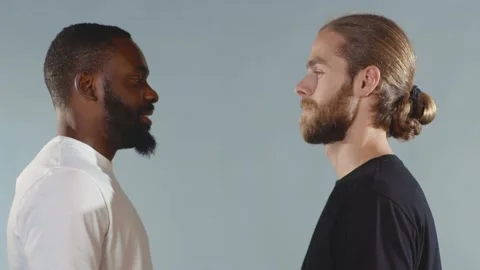 Close up Black man and white man hugging and smiling on grey background Video stock 133640525