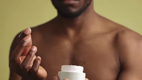 Close-up of a black man applying hand cream, doing a daily beauty treatment at 스톡 동영상 233612527