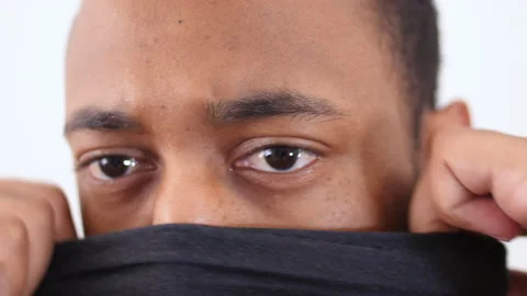 Close up of a black man putting on black neck gaiter Stock Footage 137849797