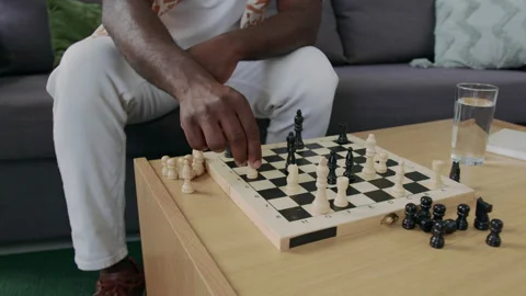 Close-Up of Black Man Sitting on Sofa, Playing Chess against Himself Stock Footage 290467859