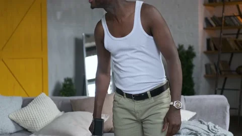 Close-up of a black man vacuuming the couch Stock-Footage 141623793