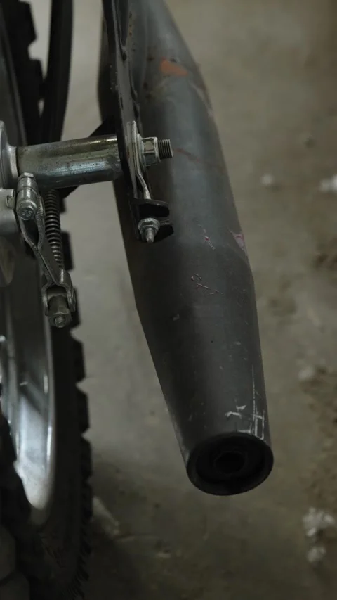 Close-up of a black matte motorcycle exhaust muffler pipe attached to frame Stock Footage 337890404