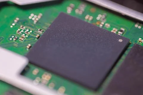 Close up of black microchip mounted on green printed circuit board with ele.. Stock-Fotos