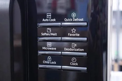 Close up of a black microwave control panel showing electronic push buttons.. Stock Photos