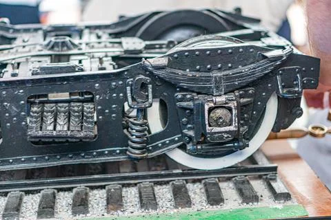 Close-up of a black model train on tracks with metallic elements, partially t Stock Photos