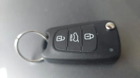 Close-up of a black modern car key fob with lock and unlock buttons Stock Footage 335072488