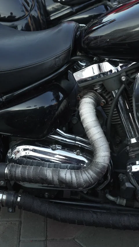 Close-up of black motorcycle engine with exhaust pipe thermal wrap. Stock Footage 341135243