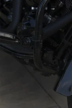 Close-up of black motorcycle engine guard and surrounding components 스톡 사진