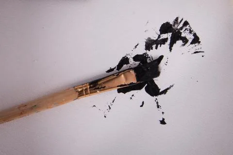 Close up black paint splatter on white canvas Stock Photos