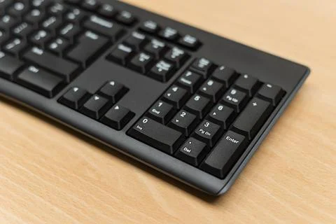Close-up of black PC computer keyboard on modern wooden wooden desk Stock Photos
