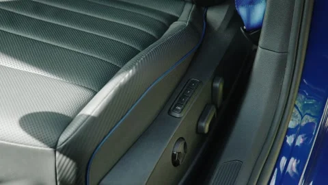 Close-up of black perforated leather driver's seat with blue stitching and power Stock Footage 255735434