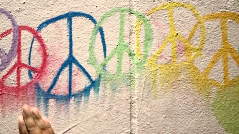 Close up of a black persons hand adding finishing touches to a peace sign Stock Footage 134430578
