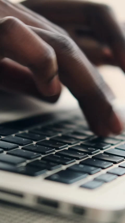 Close-up of a Black person's hands typing on a laptop keyboard Stock Footage 326162861