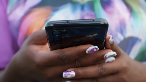 Close-up of black phone in hands of african woman Stock Footage