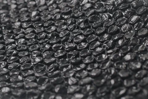 Close up of black plastic bubbles on a bubble wrap. Stock Photos