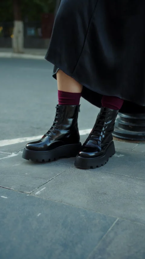 Close-up of black platform boots tapping on pavement Stock Footage 317336613