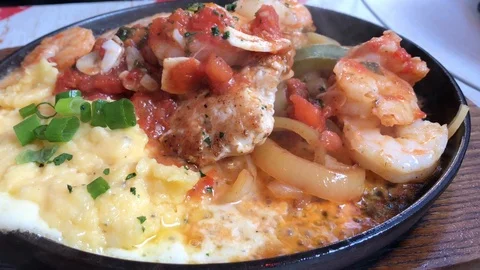 Close up of black roaster with cooking chicken, potato, tomato, and cheese. Stock Footage 104200107
