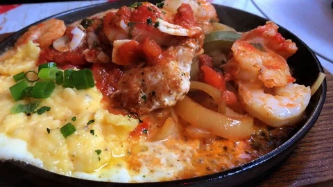 Close up of black roaster with cooking chicken, potato, tomato, and cheese. Stock Footage 104203866