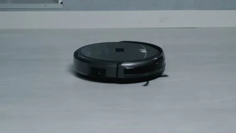 Close-up of a black round robot vacuum cleaner that cleans the apartment Stock Footage 139650273
