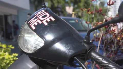 Close-up of Black Scooter Headlight with Ride Me Sticker Stock Footage 342563265