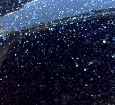 A close up of a black surface with blue glitter on it Stock-Fotos