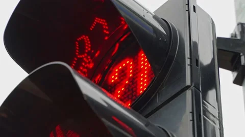 A close-up of a black traffic light counts down the time for pedestrians with a Stock Footage 218950218