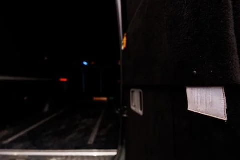 Close-up of black train side panel with reflective strip near dark railway .. Stock Photos