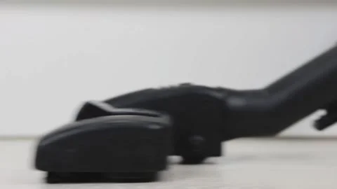 Close-up of a black vacuum cleaner brush cleaning white floors Stock Footage 130720844