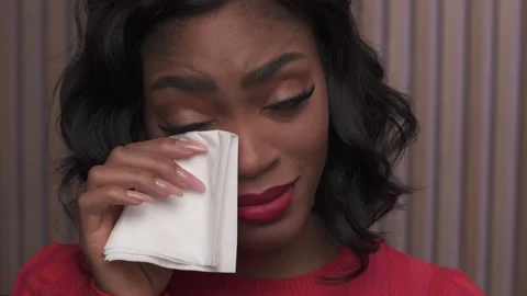Close up on a black woman's face crying, wiping tears with a tissue. Stock Footage 179580281