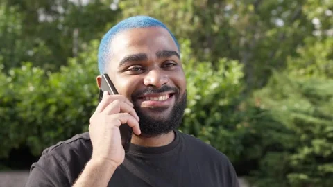 Close-up of black young man talking to a friend with mobile phone,technology 스톡 동영상 285659072