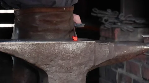 Close Up of Blacksmith Hammering Glowing Red Hot Metal on Anvil Video stock 329740816