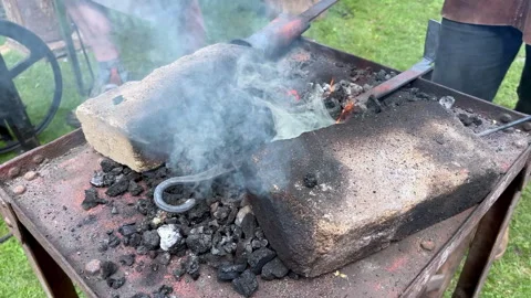 Close up of a blacksmith heating coal and stoking a forge to create glowing Video stock 331565493