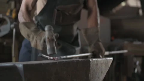 Close up of a blacksmith, in a leather apron, hammering red-hot iron. Stock Footage 253201214