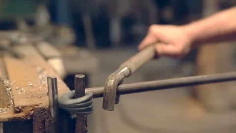 Close-up blacksmith shapes the metal manually Stockbeeldmateriaal 76396383