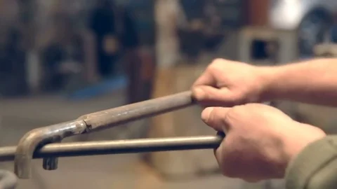 Close-up blacksmith shapes the metal manually Stock Footage 77027272