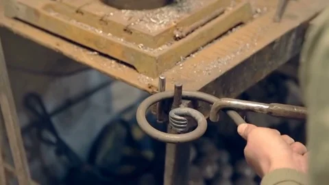 Close-up blacksmith shapes the metal manually 動画素材 77027371