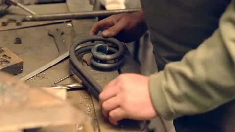 Close-up blacksmith shapes the metal manually Stock Footage 77028497