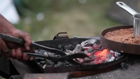 Close-up A blacksmith turns a molten red metal horseshoe over the fire Vídeo Stock 164895431