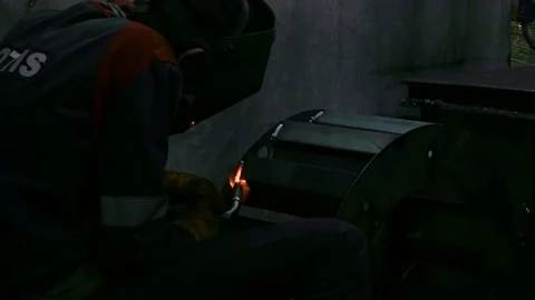 Close-up blacksmith welder in protective mask works with metal using a welding Stock Footage 138819078