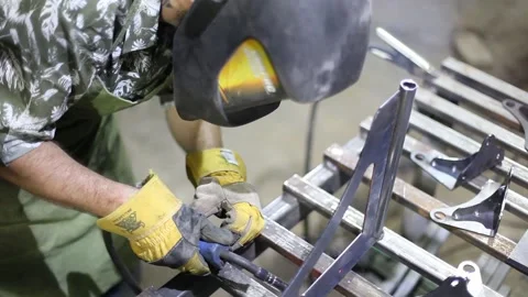 Close-up blacksmith welder in protective mask works with metal using a welding Stock Footage 139588041
