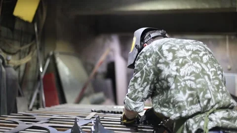 Close-up blacksmith welder in protective mask works with metal using a welding Stock Footage 139589294