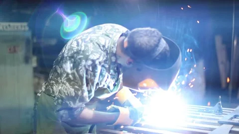 Close-up blacksmith welder in protective mask works with metal using a welding Stock Footage 139589416