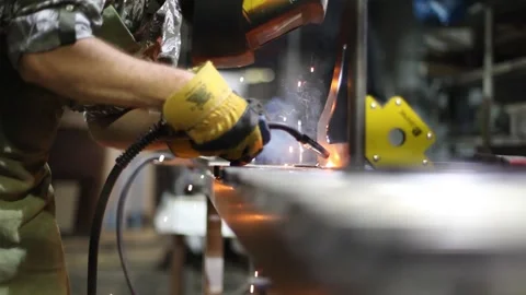 Close-up blacksmith welder in protective mask works with metal using a welding Stock Footage 139589796